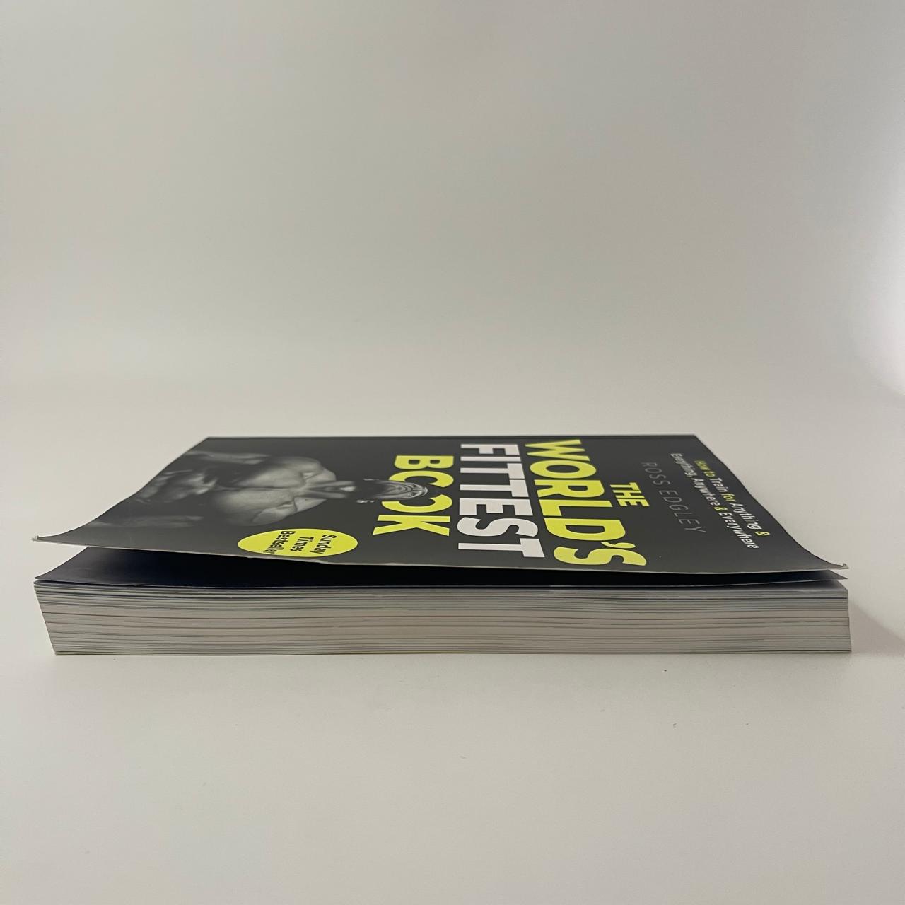 Stack of books titled 'The World's Fittest Book' on a white background